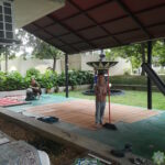 Beberapa jemaah sedang membersihkan permaidani dan tikar menggunakan penyedut hampagas dan penyapu.