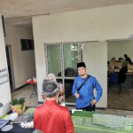 Petugas 'Open House' bergambar di hadapan meja laksa.